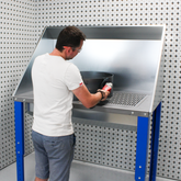Person using the downdraft steel unit on white background
